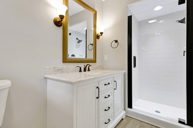 bathroom featuring vanity, wood-type flooring, and a shower with door