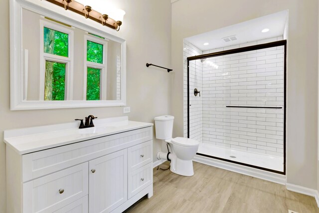 bathroom with vanity, a shower with shower door, wood-type flooring, and toilet