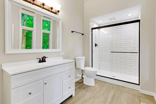 bathroom featuring hardwood / wood-style flooring, vanity, toilet, and walk in shower