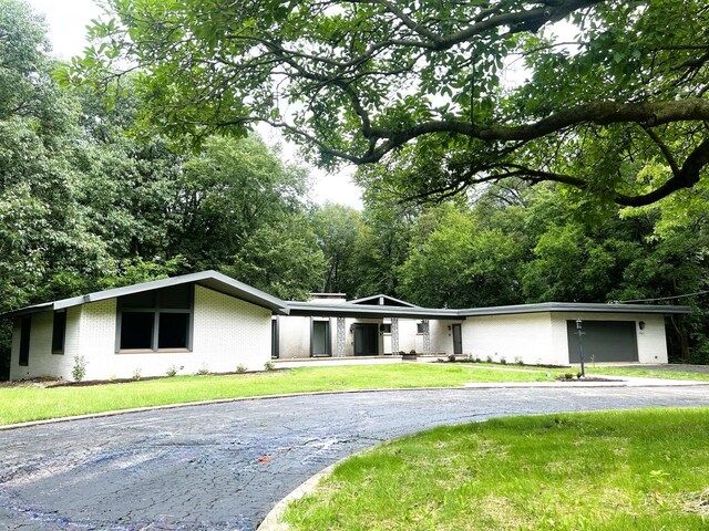 ranch-style house featuring a garage and a front lawn