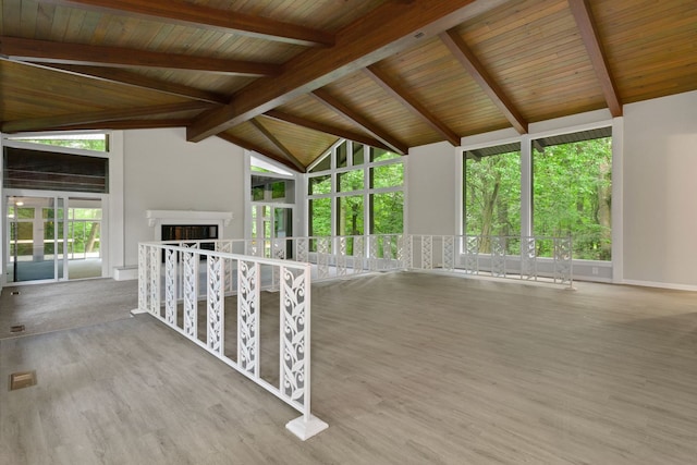 unfurnished living room with wood-type flooring, vaulted ceiling with beams, and wooden ceiling