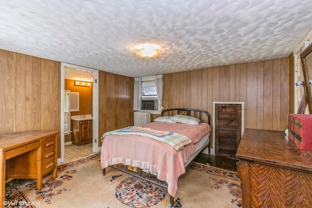 carpeted bedroom featuring radiator, wood walls, and a textured ceiling