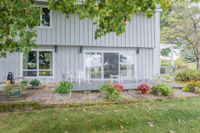 rear view of house with a lawn and a deck