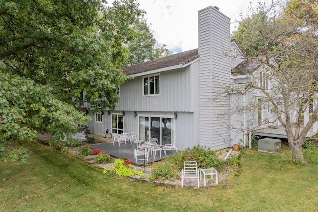 rear view of property featuring a lawn and a patio area