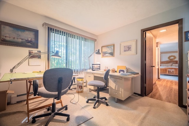 office area with baseboard heating and light wood-type flooring