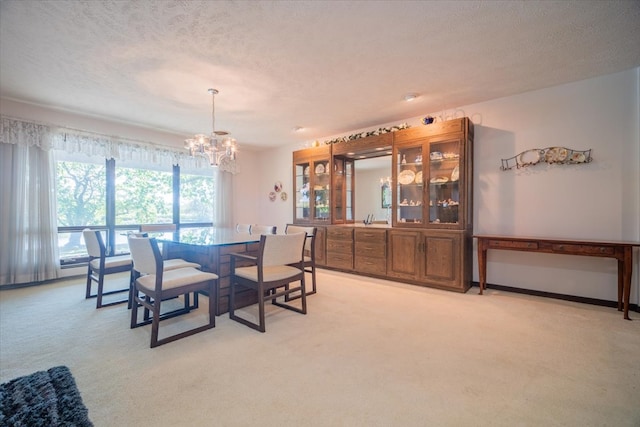 carpeted dining space with a chandelier and a textured ceiling