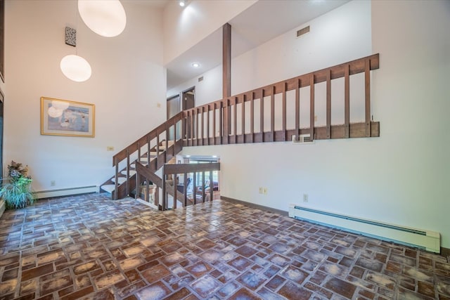 interior space featuring baseboard heating and a high ceiling