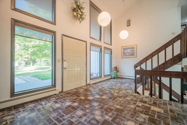 entrance foyer with a baseboard heating unit and high vaulted ceiling