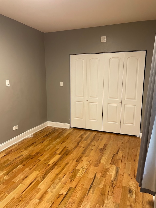 unfurnished bedroom featuring light hardwood / wood-style flooring and a closet