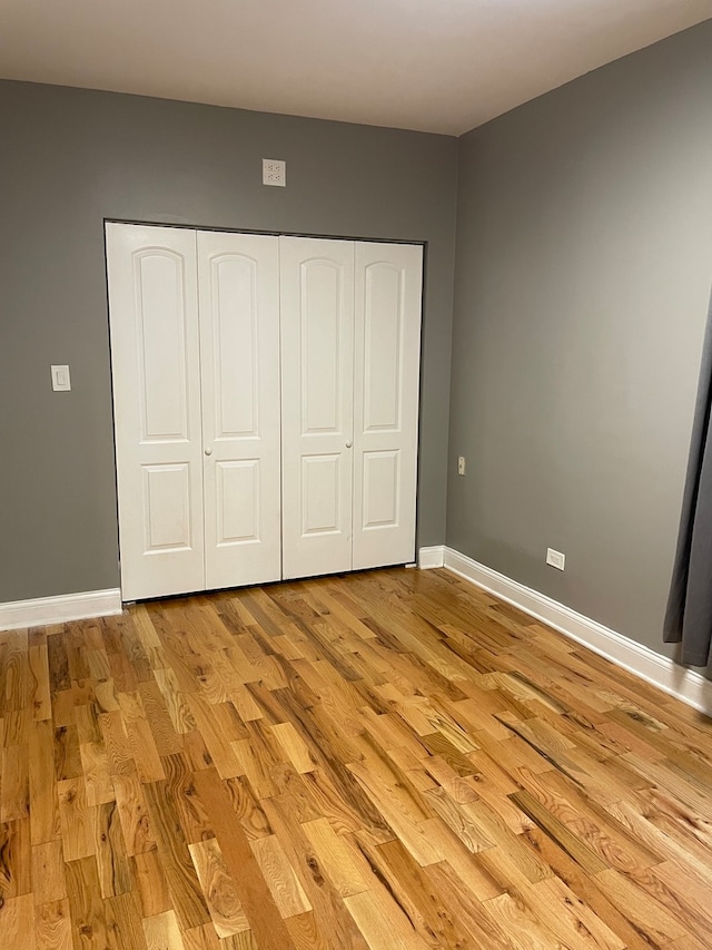 unfurnished bedroom featuring a closet and light wood-type flooring