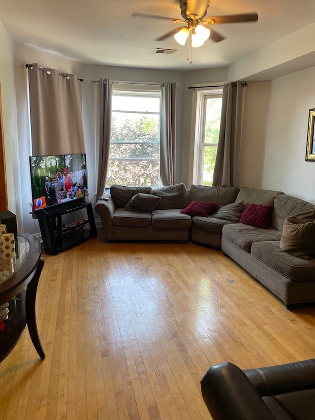 living room with light hardwood / wood-style floors and ceiling fan