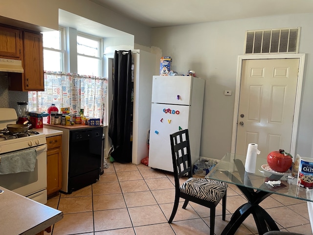 kitchen featuring light tile patterned flooring, range hood, and white appliances