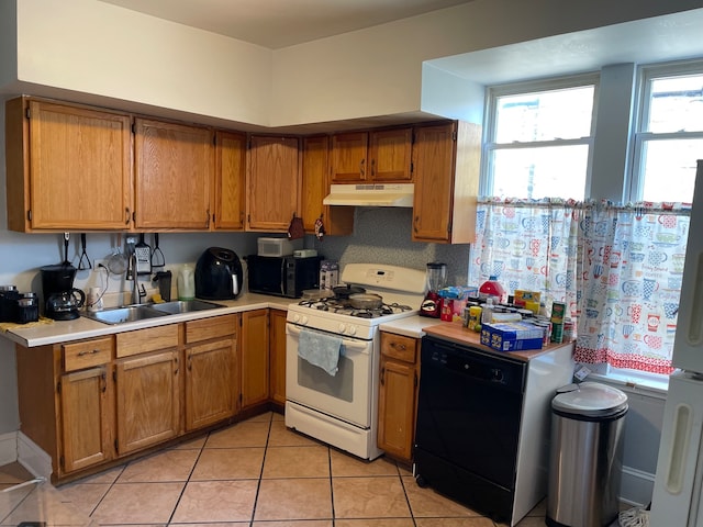 kitchen featuring light tile patterned floors, black appliances, and sink