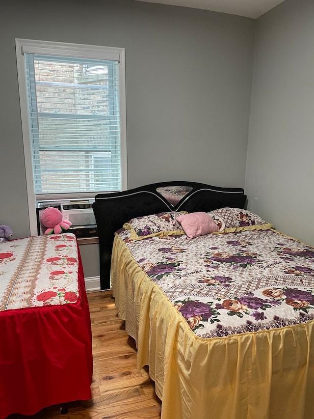 bedroom with cooling unit and light wood-type flooring