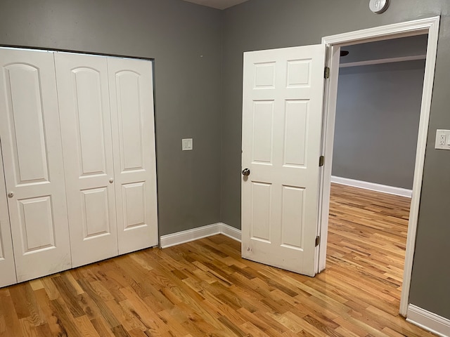 unfurnished bedroom featuring a closet and light wood-type flooring