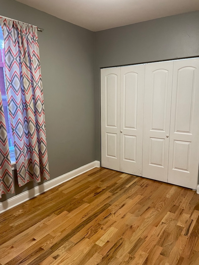 unfurnished bedroom with light hardwood / wood-style floors and a closet