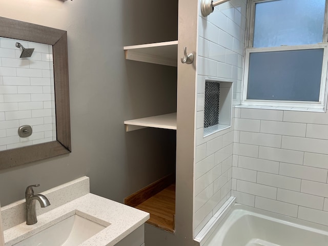 bathroom featuring tiled shower / bath and vanity