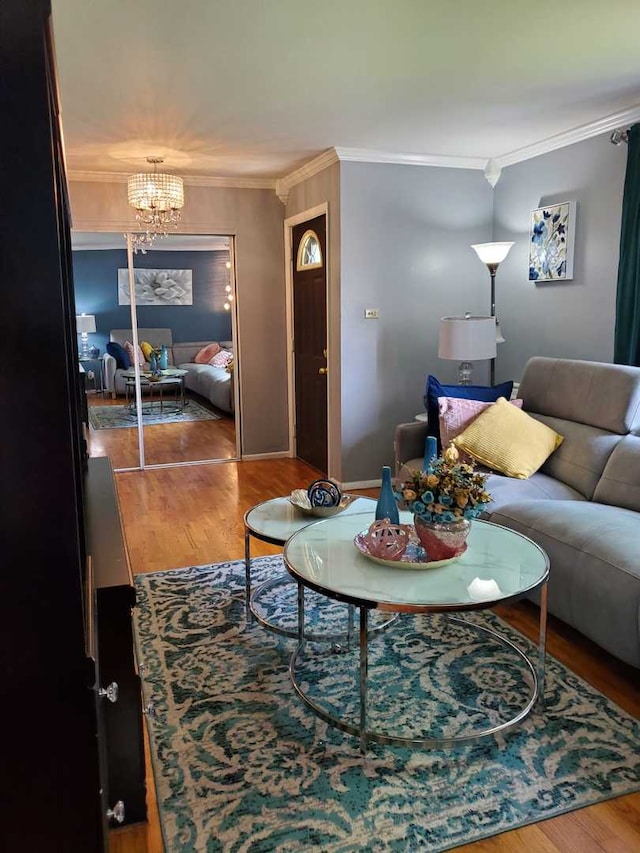 living room with ornamental molding, hardwood / wood-style flooring, and a notable chandelier