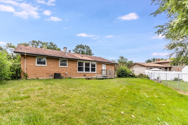 rear view of property featuring a deck and a yard