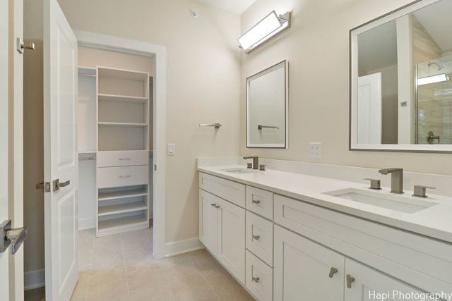 bathroom with tile patterned flooring, vanity, and walk in shower