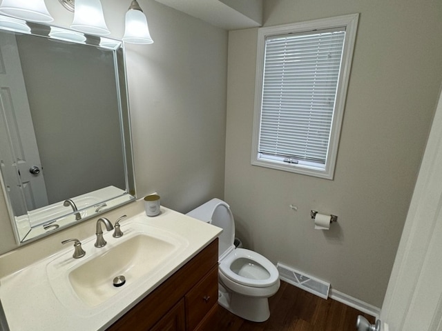 bathroom with hardwood / wood-style flooring, vanity, and toilet