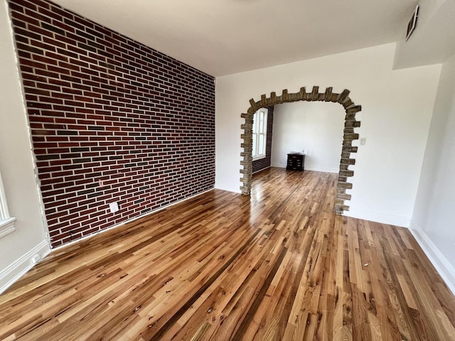 interior space featuring brick wall and wood-type flooring