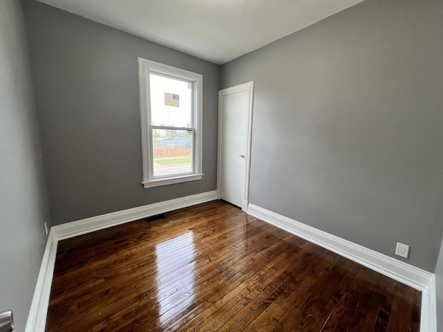 spare room featuring dark wood-type flooring