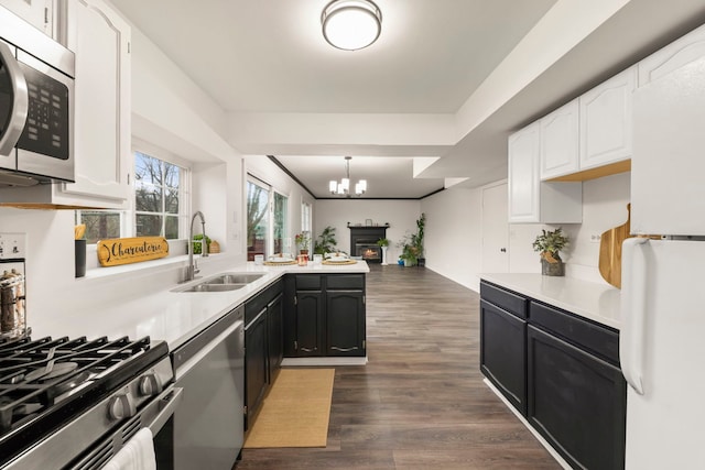 kitchen featuring light countertops, appliances with stainless steel finishes, a sink, and white cabinets