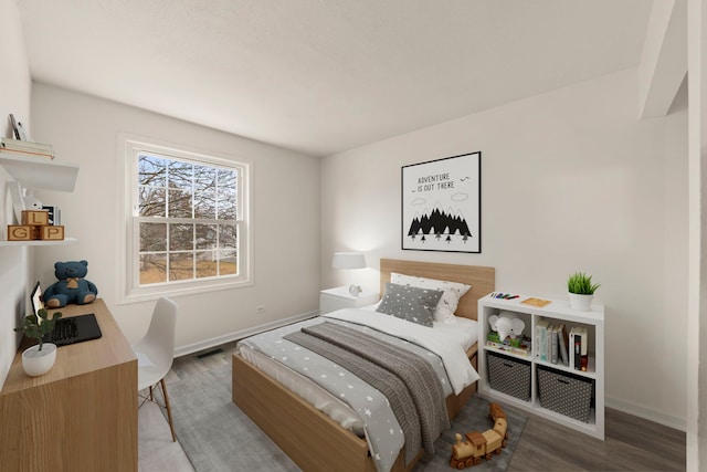 bedroom with baseboards and wood finished floors