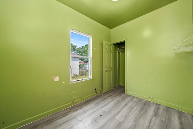 unfurnished bedroom with light wood-type flooring and a closet