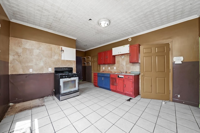 kitchen featuring ornamental molding, sink, gas range oven, and light tile patterned floors