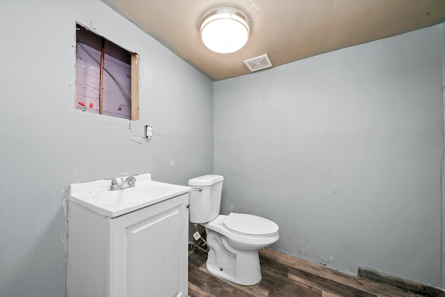 bathroom featuring vanity, toilet, and hardwood / wood-style floors