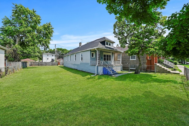 rear view of house featuring a lawn