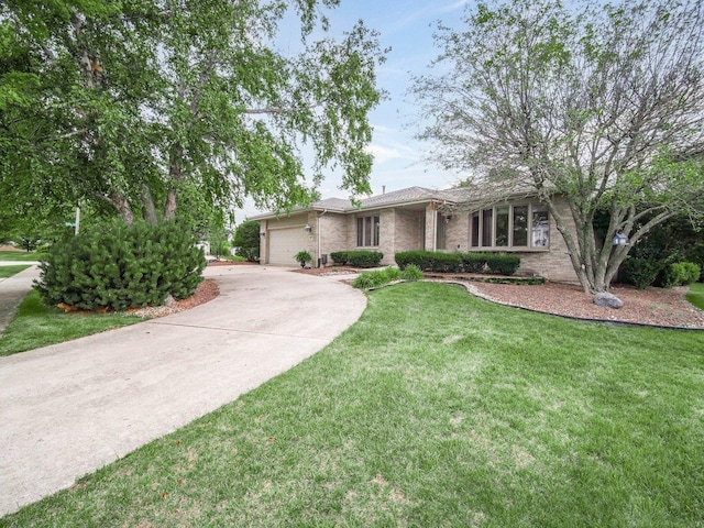 view of front of property with a front yard, concrete driveway, brick siding, and an attached garage