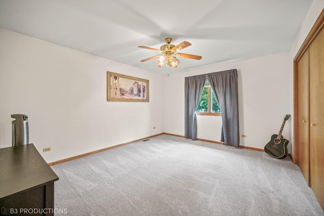 unfurnished bedroom featuring carpet, a closet, visible vents, ceiling fan, and baseboards