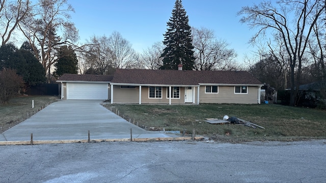 ranch-style house featuring covered porch, a garage, and a front lawn