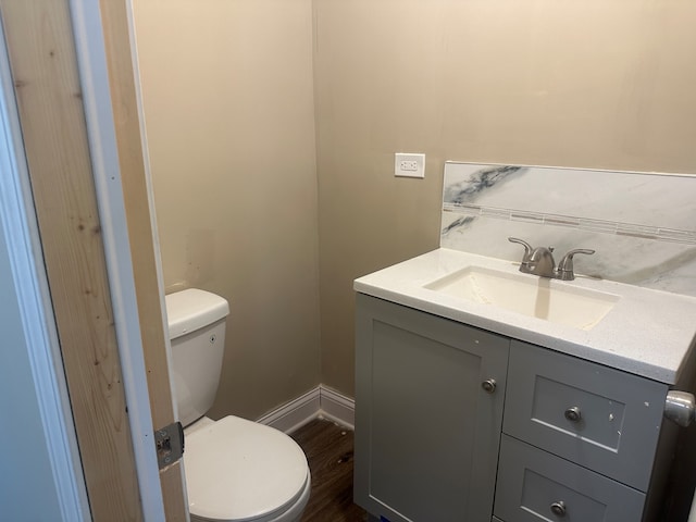 bathroom with toilet, vanity, and hardwood / wood-style flooring