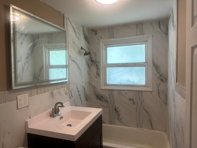 bathroom featuring vanity, tile walls, and tiled shower / bath