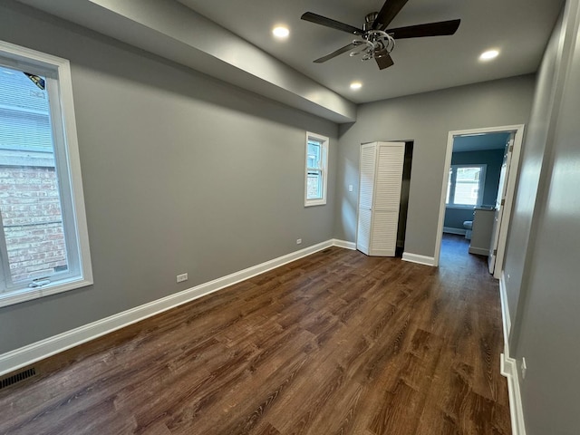 unfurnished bedroom with dark wood-type flooring, ceiling fan, and a closet