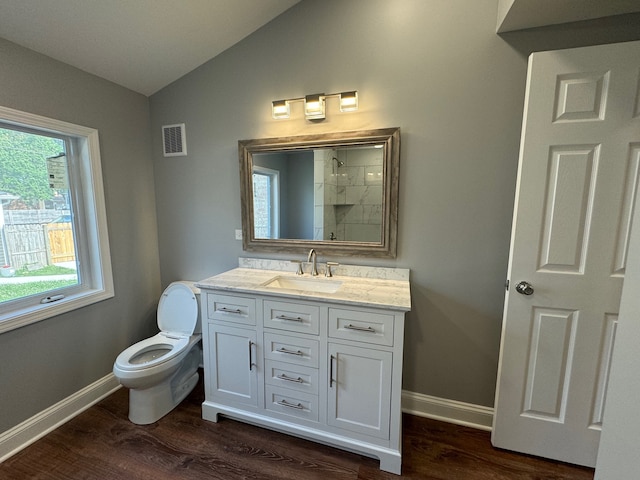 bathroom with hardwood / wood-style flooring, vaulted ceiling, vanity, and toilet