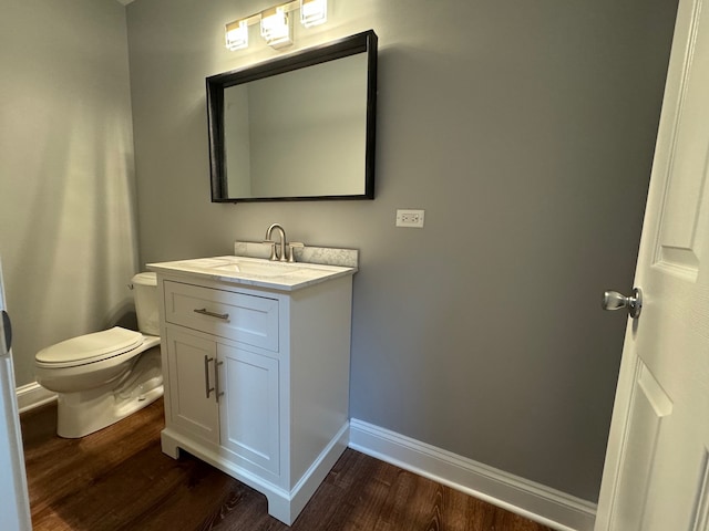 bathroom featuring hardwood / wood-style flooring, toilet, and vanity