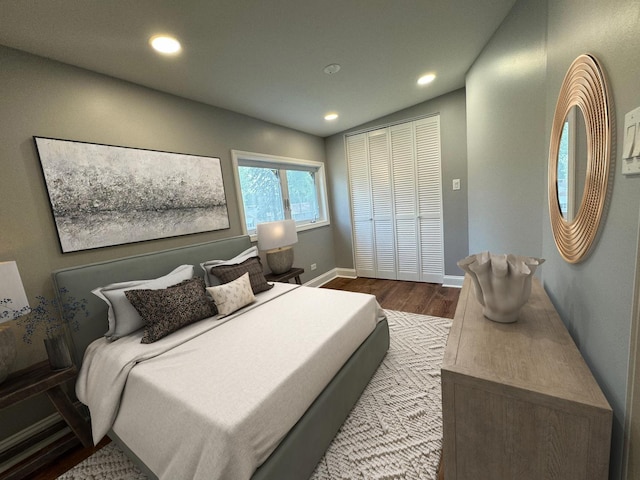 bedroom with a closet, lofted ceiling, and light hardwood / wood-style flooring