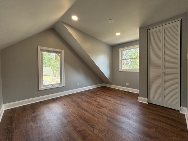 additional living space featuring lofted ceiling and dark hardwood / wood-style flooring