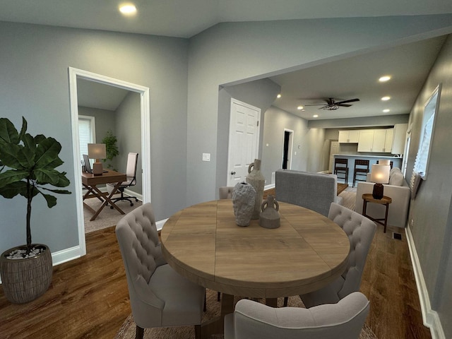 dining area featuring ceiling fan, lofted ceiling, and dark hardwood / wood-style flooring