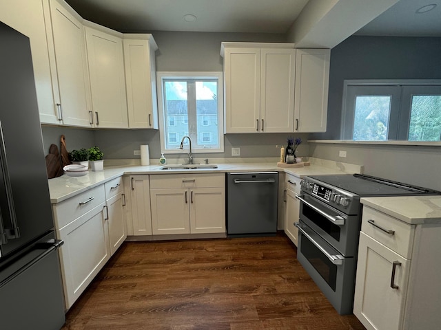 kitchen featuring appliances with stainless steel finishes, white cabinets, dark hardwood / wood-style floors, and sink