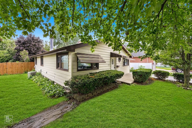 view of side of home featuring a yard and central AC unit