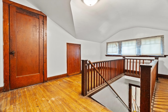 hallway featuring vaulted ceiling and light wood-type flooring