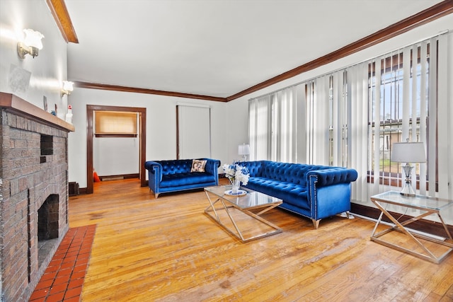 living room featuring light hardwood / wood-style flooring, a brick fireplace, and crown molding