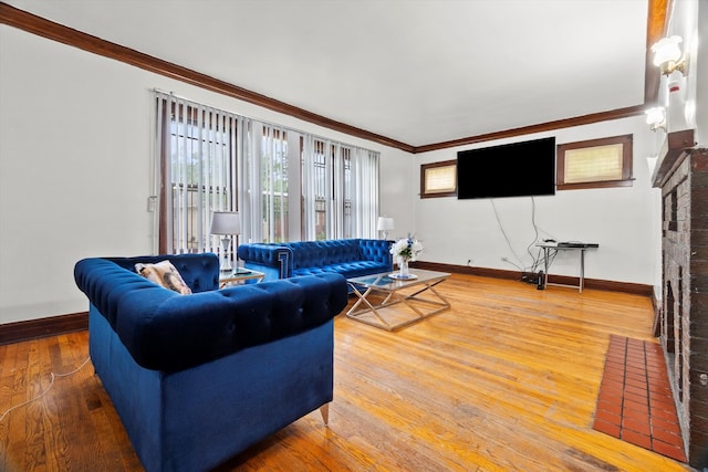 living room with light hardwood / wood-style floors, a brick fireplace, and ornamental molding