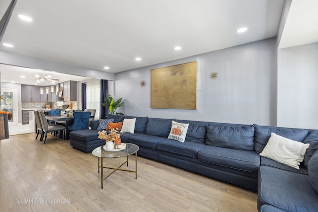 living room featuring light hardwood / wood-style flooring, a chandelier, and plenty of natural light